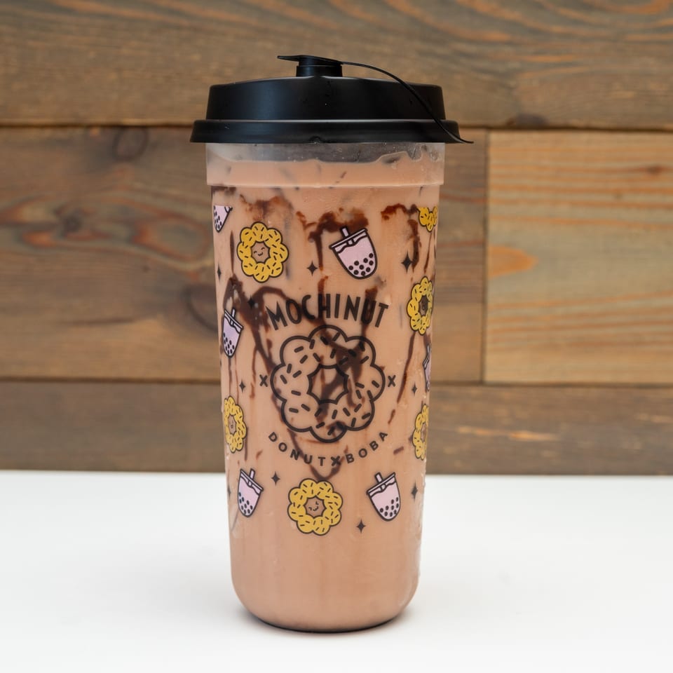 Mochinut chocolate boba drink with chocolate syrup swirls in a branded cup.