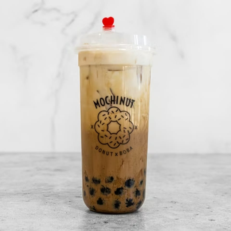 Mochinut boba tea with a red heart stopper, featuring a donut logo on the cup.