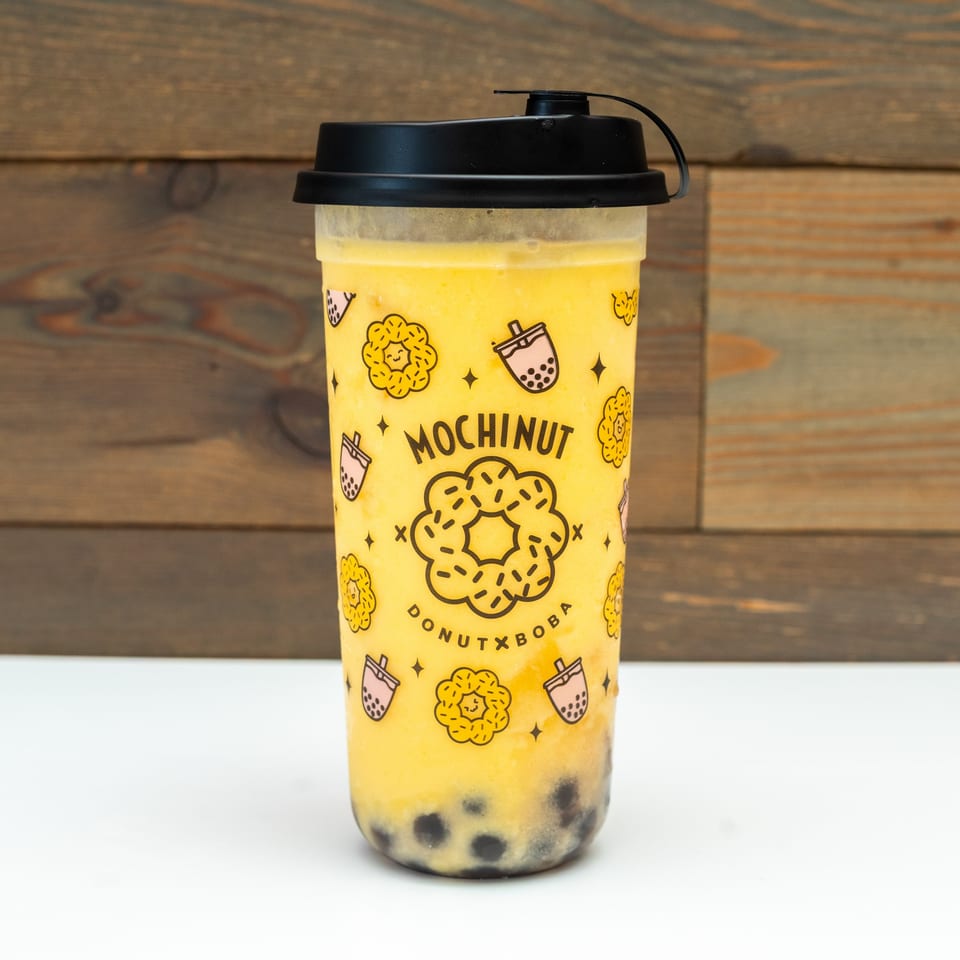 Mochinut mango boba drink with tapioca pearls, featuring the brand's logo and donut graphics.